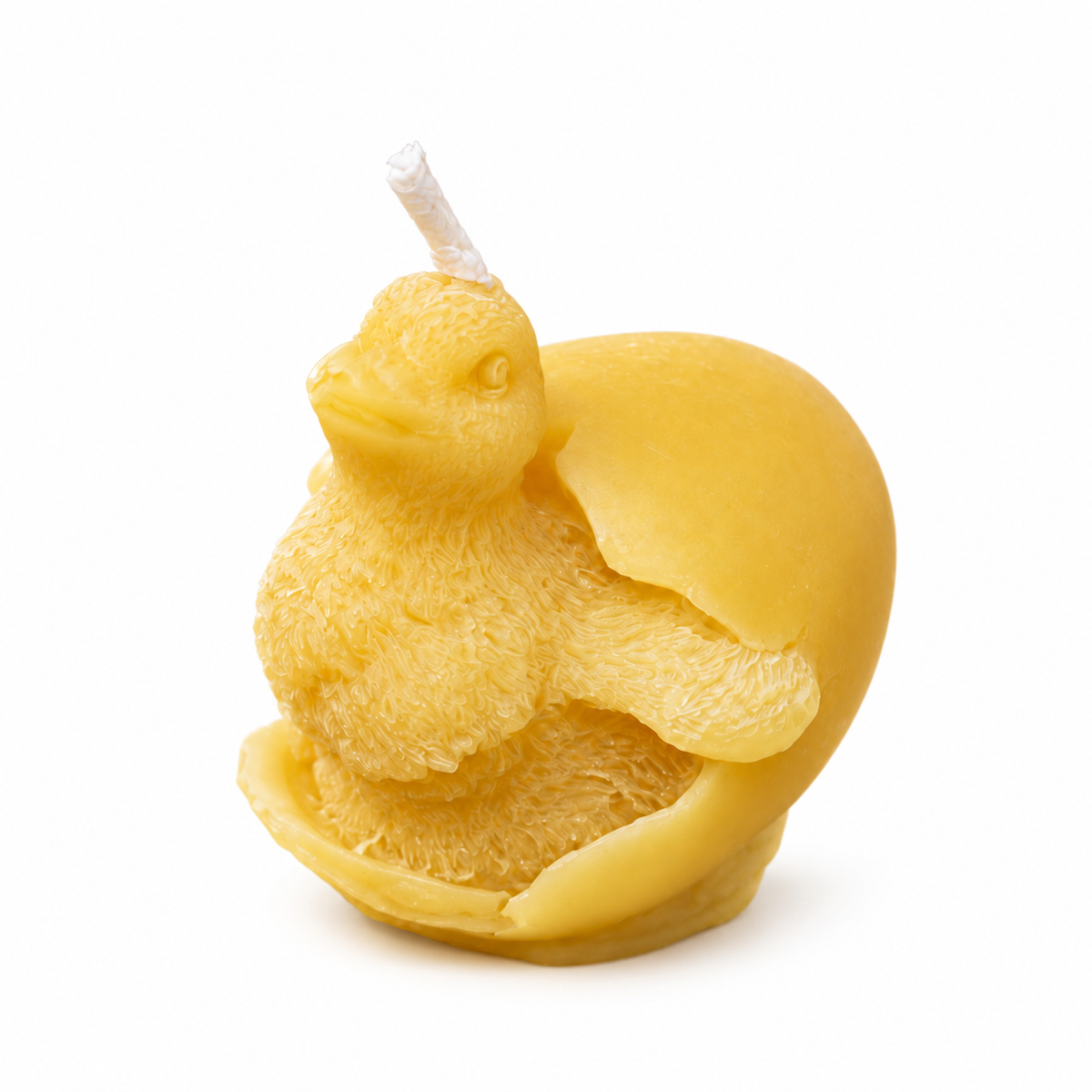 Handmade yellow baby duckling hatching from an eggshell beeswax candle on pure white background